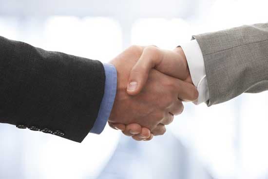 Two suited hands in a handshake